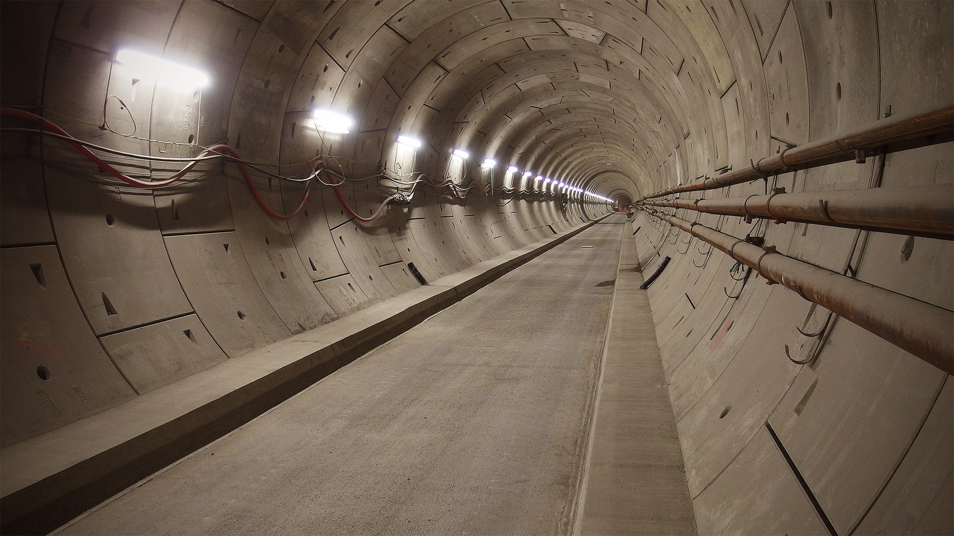 A straight tunnel climbs steadily towards a dark portal