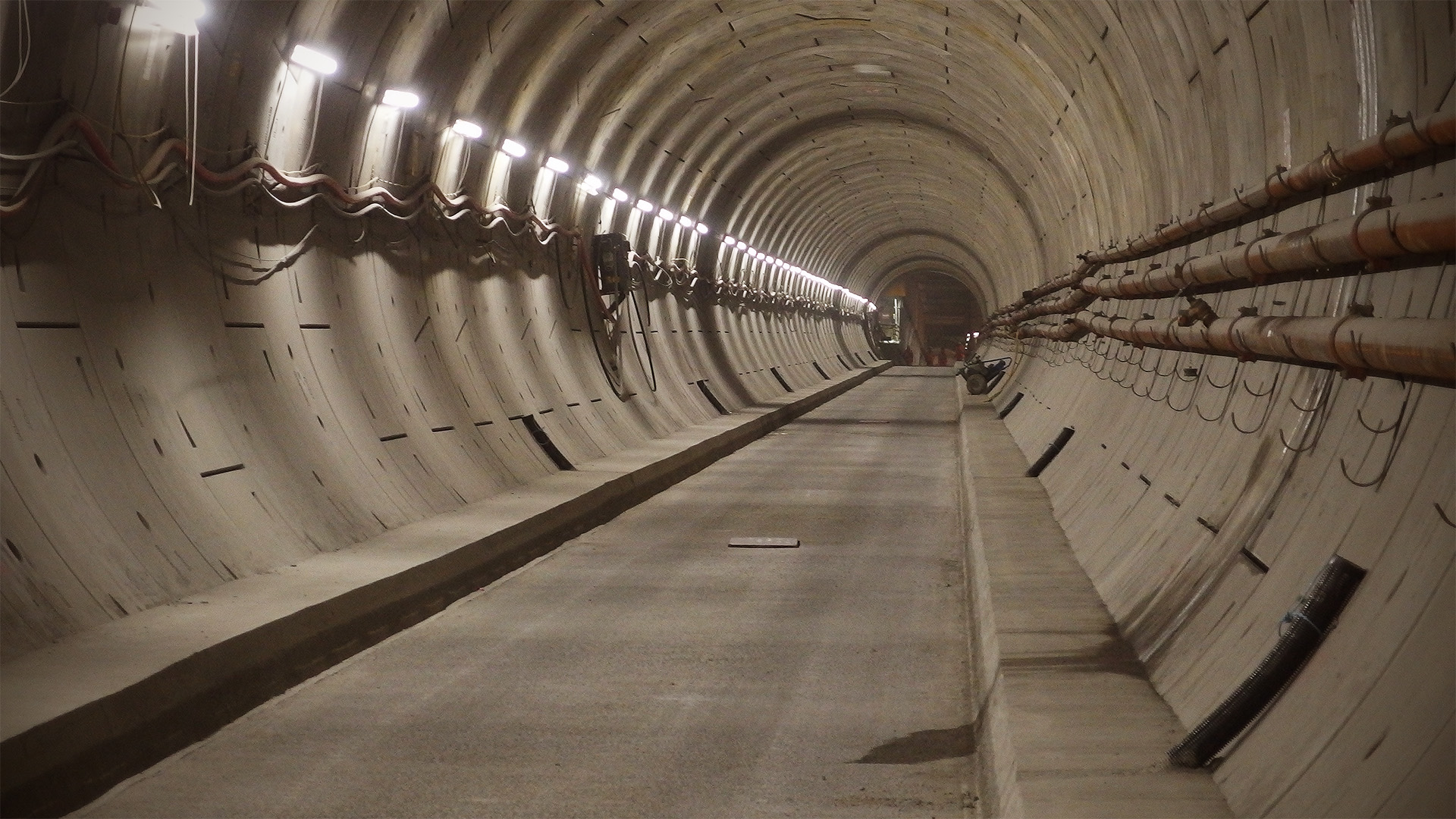 A straight tunnel climbs steadily, with a station visible at its summit